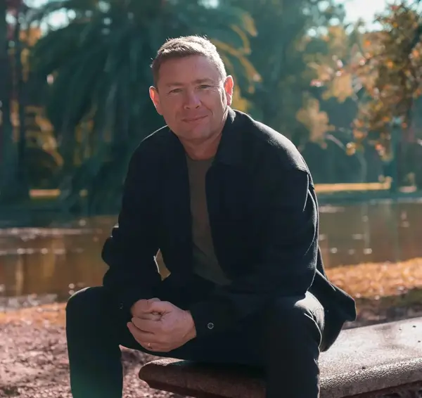 José Manuel Estrada sentado junto a un lago